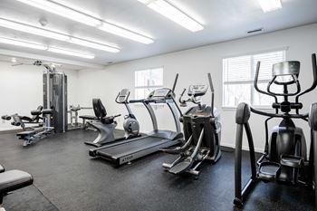 A gym with treadmills, elliptical machines, and other exercise equipment.